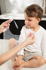 Toddler wearing clear disposable bib during meal at home